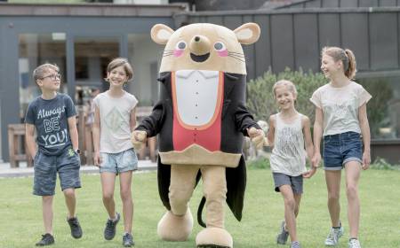 Kinder mit Maskottchen Herr Gorfion vor dem Familienhotel Gorfion Liechtenstein