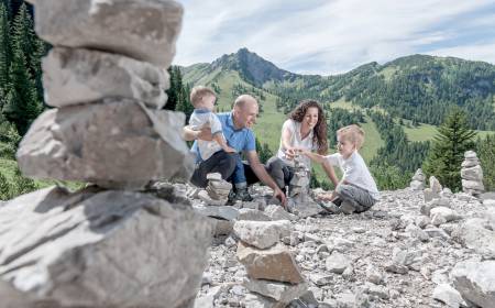 Familie baut Steinmännchen in den Liechtensteiner Alpen