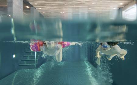 Kinder schwimmen im Hallenbad im Familienhotel Gorfion
