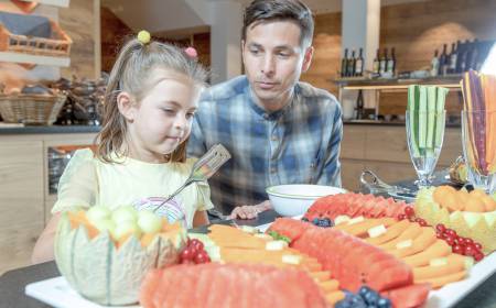 Vater und Tochter am Obstbuffet im Familienhotel Gorfion in Liechtenstein