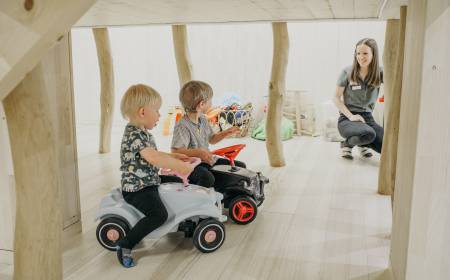 Kinder mit Bobbycar im Kids Club des Familienhotel Gorfion Liechtenstein