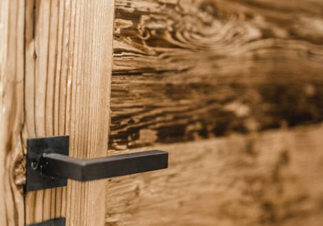 Detailaufnahme schwarzer Türgriff an Holztür