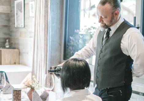 Kellner serviert Rotwein im Restaurant des Familienhotel Gorfion Liechtenstein