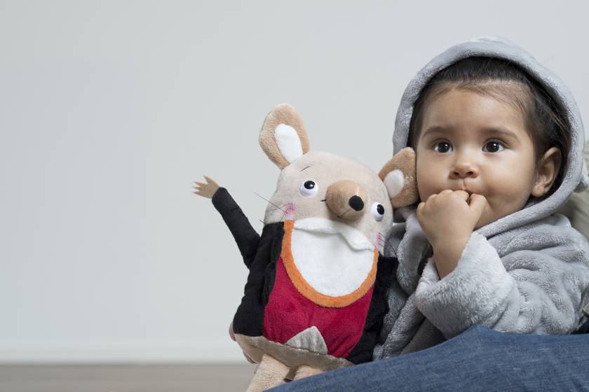 Kleinkind im Bademantel mit Kuscheltier Herr Gorfion