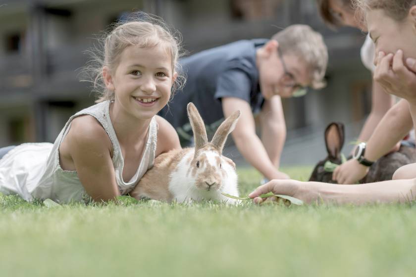 Kinder streicheln Kaninchen im Familienhotel Gorfion in Liechtenstein